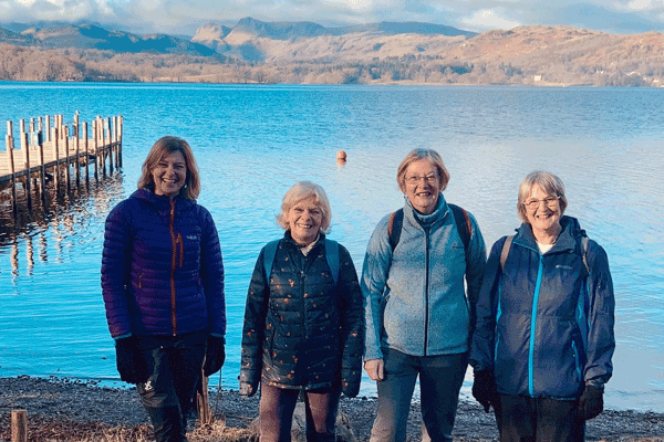 Four walkers walking 1000 miles for Carers Support South Lakes with the Lake District fells in the background